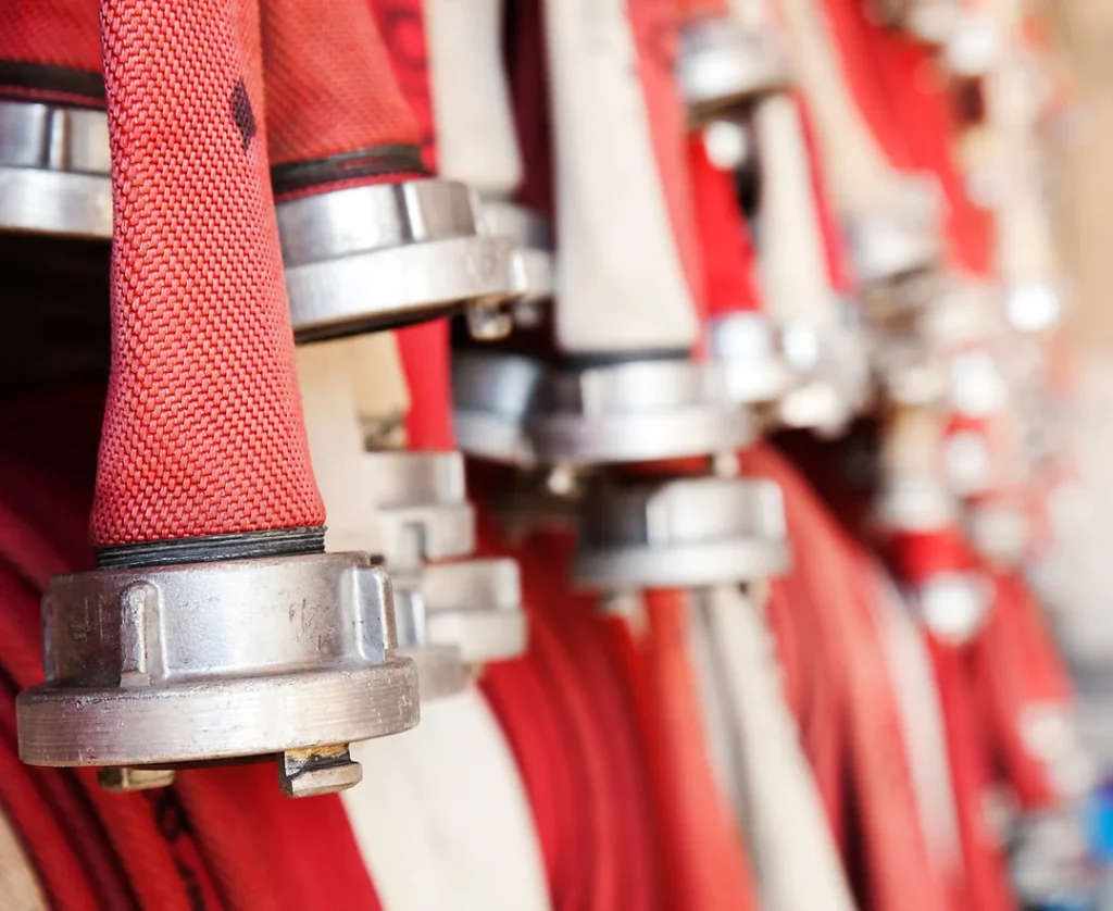 Red fire hoses hung up on a wall.